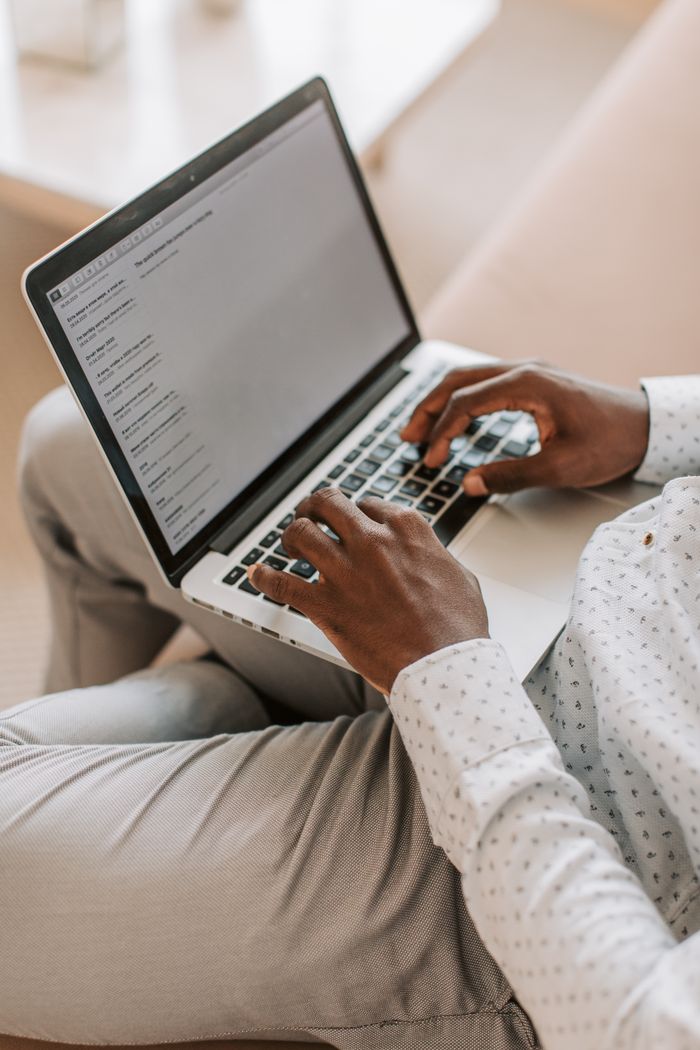 about-01 An adult typing on a laptop in a cozy home environment, focused on work.